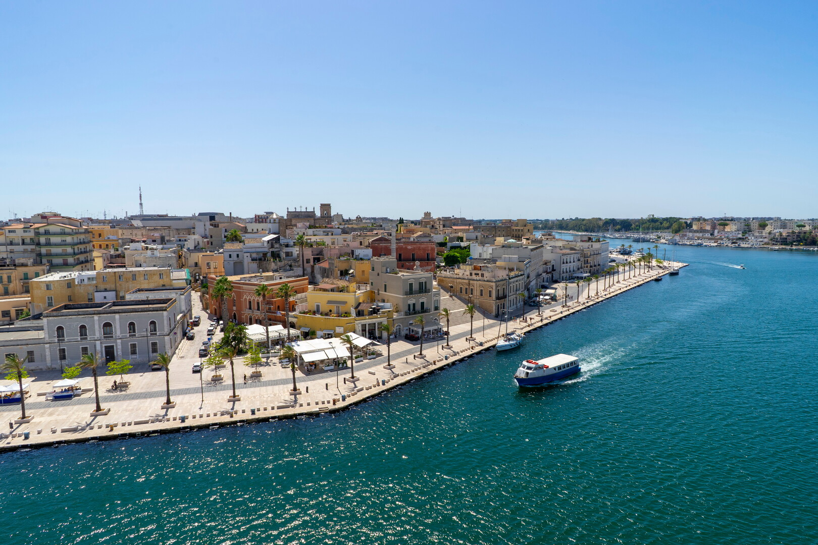The Brindisi waterfront with old town, palm trees and turquoise sea